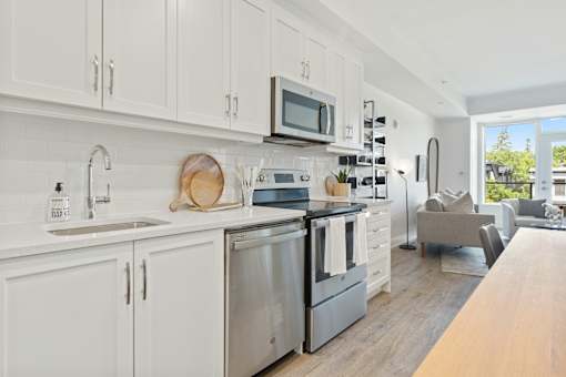 A modern kitchen with white cabinets and stainless steel appliances.
