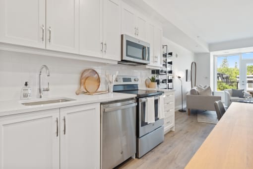 a kitchen with white cabinets and stainless steel appliances