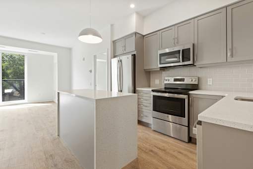 A modern kitchen with stainless steel appliances and a white countertop.