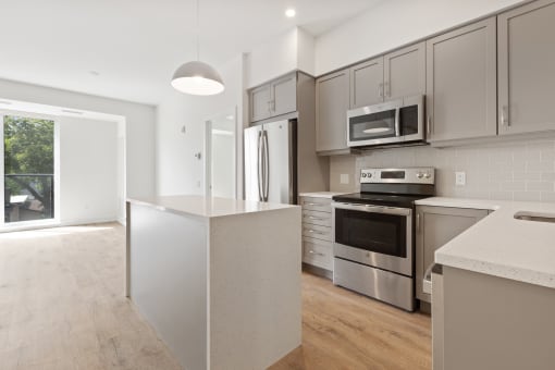 a kitchen with gray cabinets and a white island