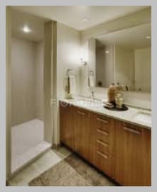 A bathroom with a sink, mirror, and shower.