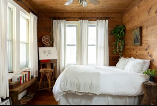 a bedroom with a bed and three windows