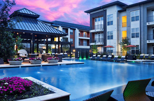a large swimming pool in front of an apartment building