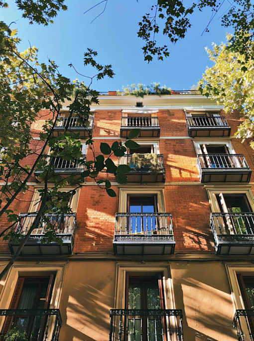 A red brick building with balconies and windows.