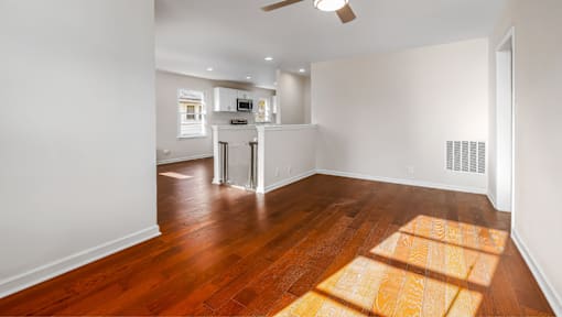 A room with a wooden floor and a ceiling fan.