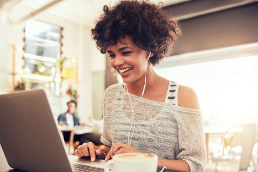 a woman smiling while working on her laptop computer