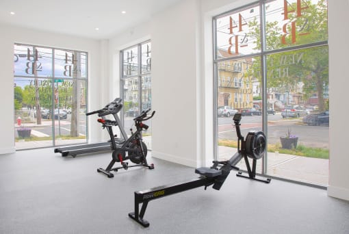 a room with two exercise bikes and a window with a view of the street
