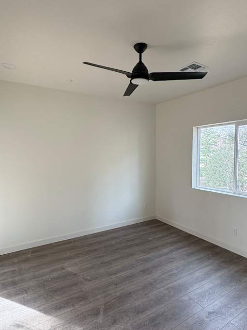 A room with a ceiling fan and a window.