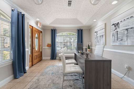a lobby with a desk and chairs and a large window