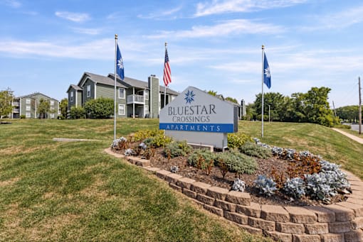 The sign in front of the building says Bluestar Crossings Apartments.
