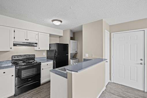 A kitchen with black appliances and white cabinets.