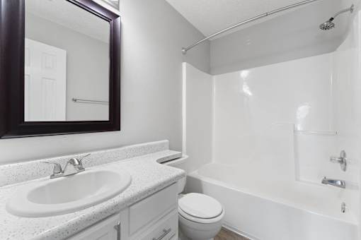 a bathroom with a sink toilet and shower and a mirror