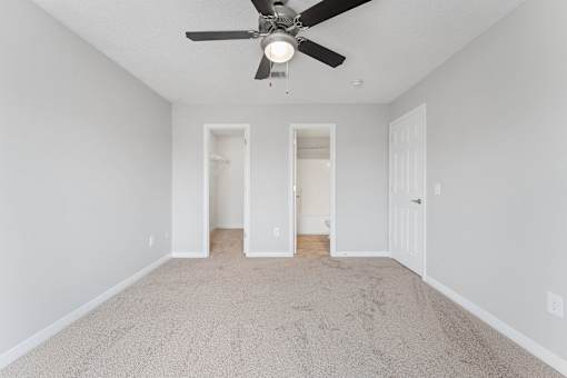 an empty living room with a ceiling fan