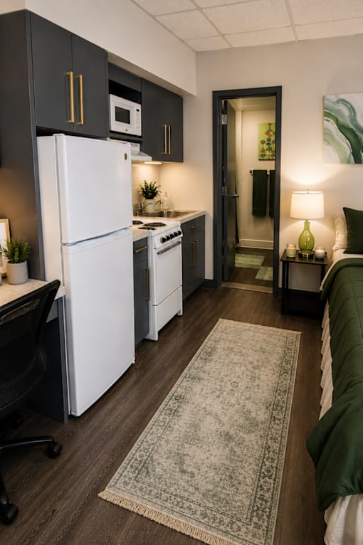 A kitchen with a white fridge and a black chair.