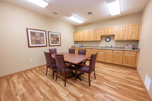 A kitchen with a table and chairs.