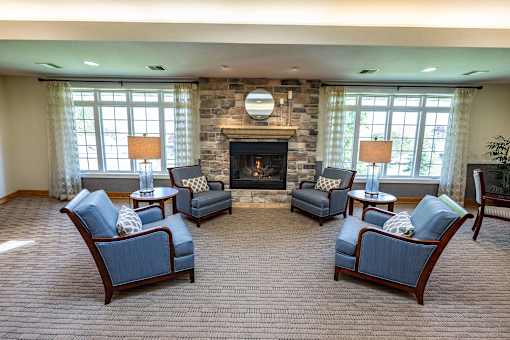 A living room with a fireplace and four chairs.