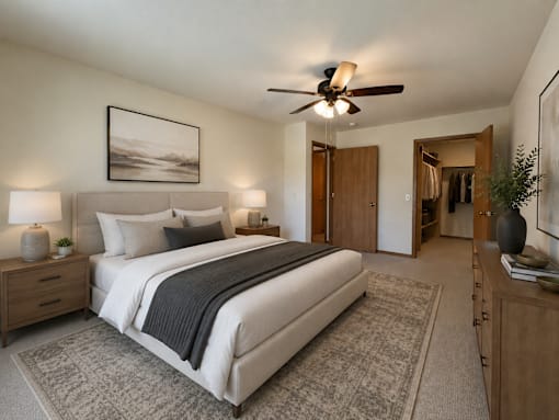 A bedroom with a large bed, a ceiling fan, and a painting on the wall.