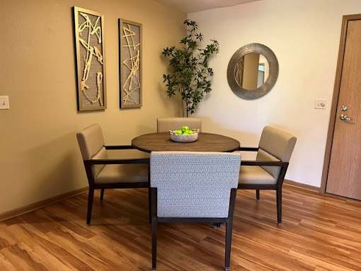 A dining room with a round table and chairs.