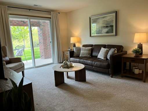 A living room with a couch, coffee table, and sliding glass doors.