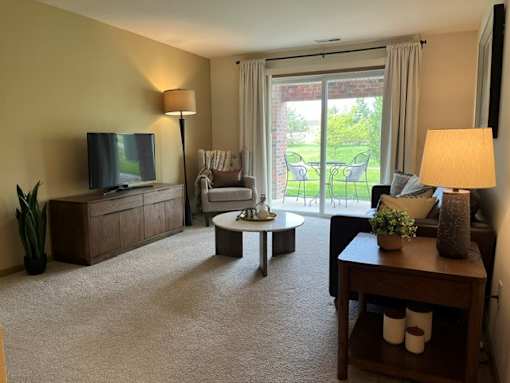 A living room with a flat screen TV and a sliding glass door.