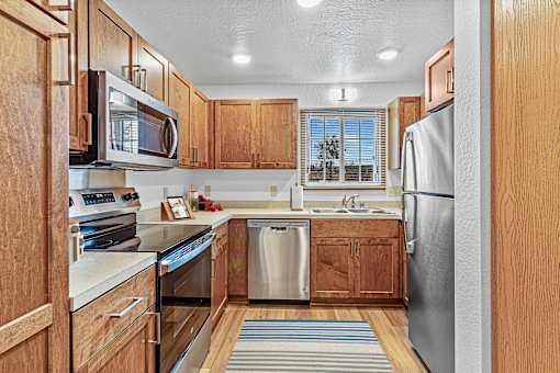A kitchen with wooden cabinets and stainless steel appliances.