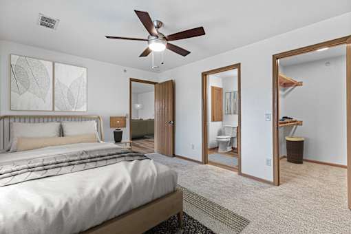 A bedroom with a large bed and a ceiling fan.