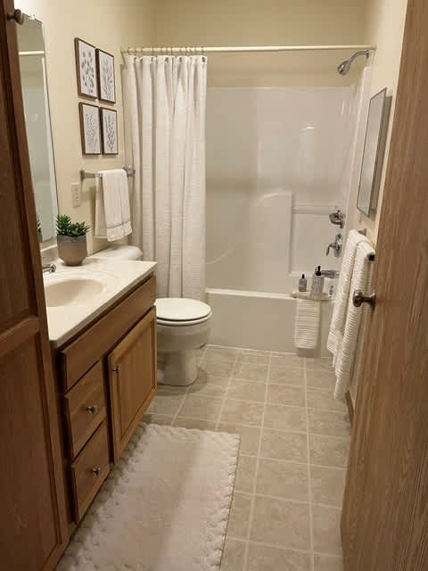 A bathroom with a toilet, sink, and shower.