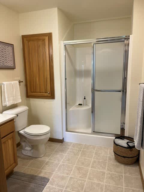 A bathroom with a toilet, sink, and shower.