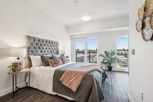 Bedroom with a bed and a large window at AVIVA Apartments in Gresham Oregon
