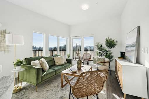 Living room with a couch and a table and a balcony at AVIVA Apartments in Gresham Oregon