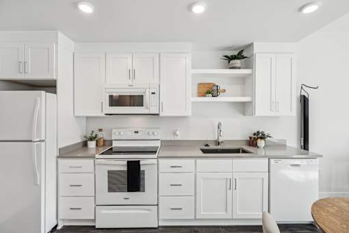White kitchen with white appliances and white cabinets at AVIVA Apartments in Gresham Oregon