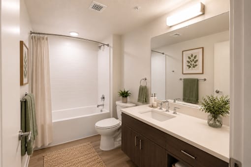A bathroom with a toilet, sink, and mirror.