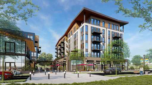 A modern building with a lot of windows and balconies is surrounded by greenery.