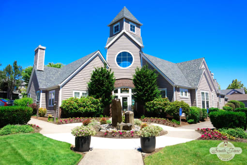 the front yard of a house with a garden and a church
