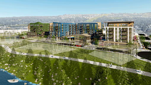 A modern building complex with a green lawn in front.