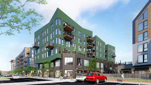 A modern building with a green roof and balconies.