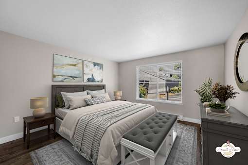 A bedroom with a large bed and a painting on the wall.