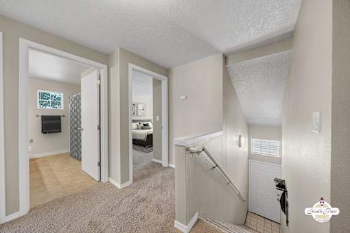 A bedroom with a white door and a carpeted floor.