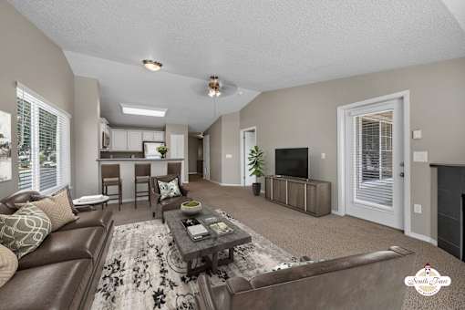 A living room with a brown leather couch and a fireplace.
