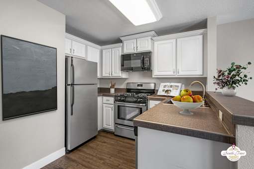 A kitchen with a refrigerator, oven, and microwave.