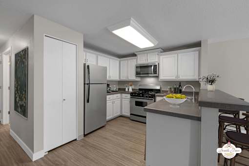 A modern kitchen with white cabinets and stainless steel appliances.