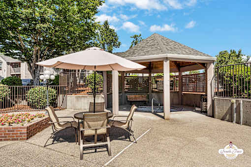 A patio with a table, chairs, and an umbrella is shown.