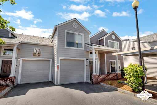 A house with a garage and a driveway in front.