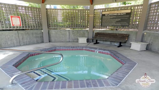 a swimming pool in a pavilion with a bench next to it