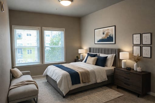 A bedroom with a large bed, a chair, and a window.