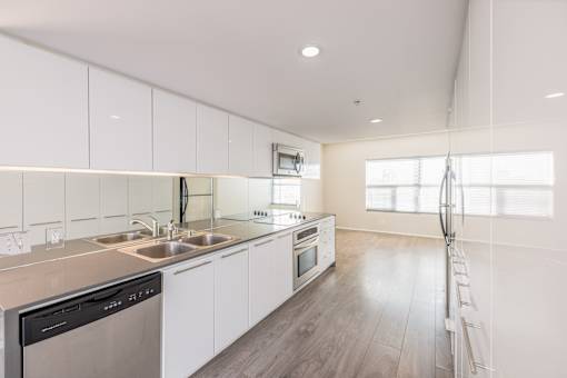 A modern kitchen with white cabinets and stainless steel appliances.