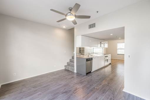A modern kitchen with a staircase leading to the upper level.