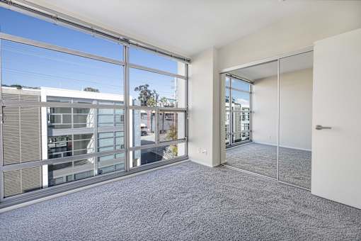A room with a large window and a view of a building outside.