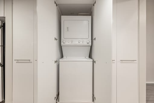 A white dishwasher is in the middle of a kitchen.