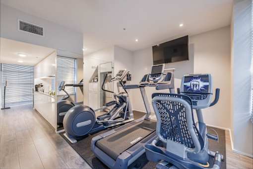 A modern home gym with a treadmill and a stationary bike.